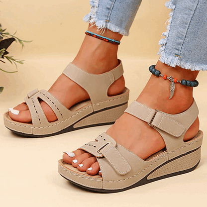 Beige Damen-Sandalen mit Keilabsatz, weicher Sohle und Klettverschluss. Perfekt für Sommer, bequem und modisch. Ideal für Freizeit und Alltag.