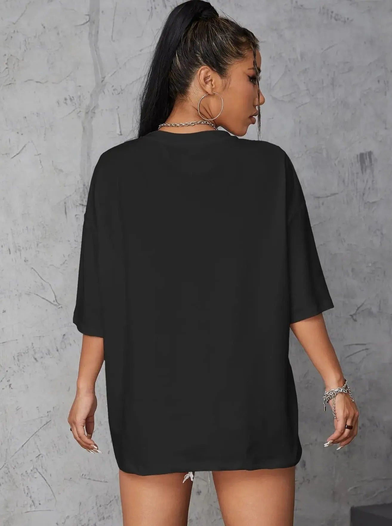 Frau in schwarzem Oversize-T-Shirt, lässiger Streetwear-Look, ideal für trendige Mode, komfortabel und stilvoll, perfekt für den Alltag.