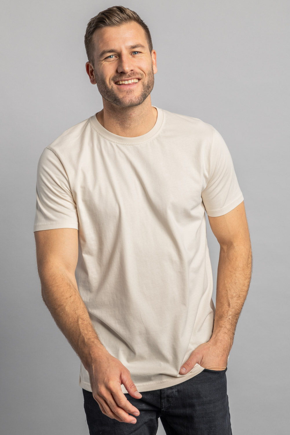 Lächelnder Mann in beigem T-Shirt, lässige Mode, Herrenbekleidung, Freizeitlook.