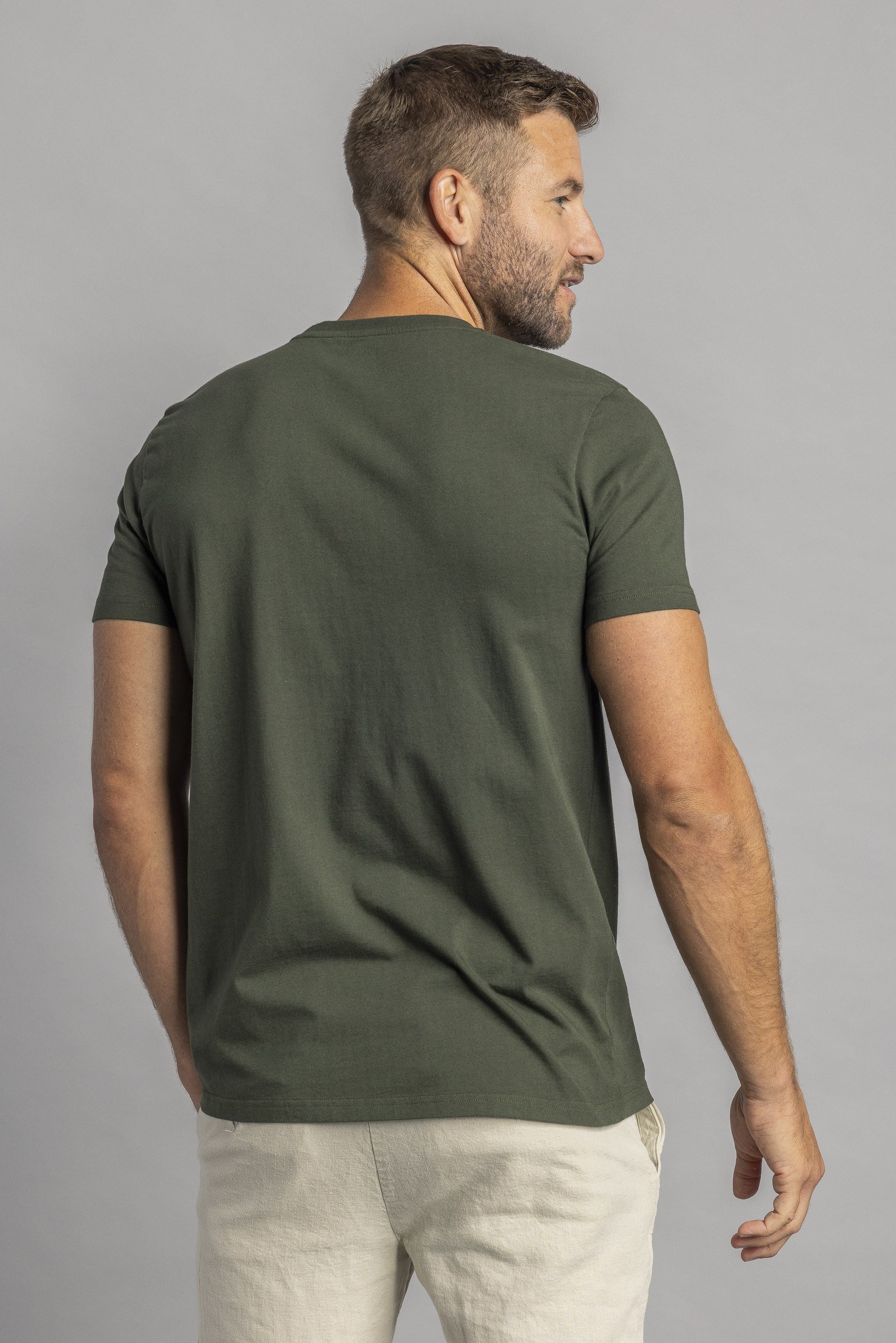 Mann trägt olivgrünes T-Shirt, Rückansicht, lässige Mode, Herrenbekleidung, Baumwolle.