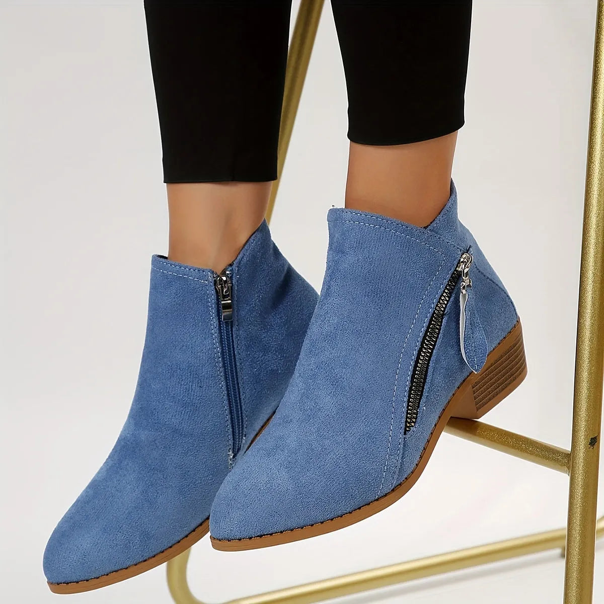 Blaue Damen-Stiefeletten aus Wildleder mit seitlichem Reißverschluss, flachem Absatz und modernem Design. Perfekt für Herbstmode und Alltagslooks.