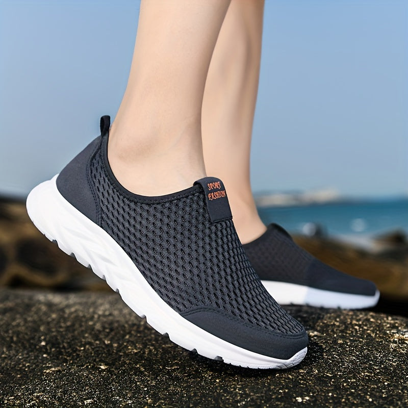 Schwarze, atmungsaktive Sportschuhe mit weißer Sohle auf Felsen am Meer. Ideal für Outdoor-Aktivitäten und Freizeit. Leicht und komfortabel.