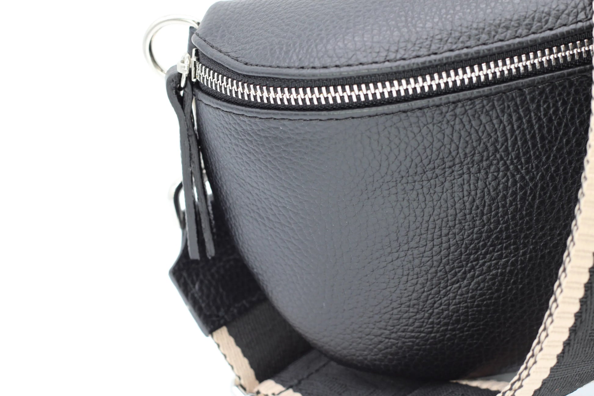 Schwarze Leder-Gürteltasche mit silbernem Reißverschluss und verstellbarem Riemen. Modisches Accessoire, ideal für Reisen und Alltag.