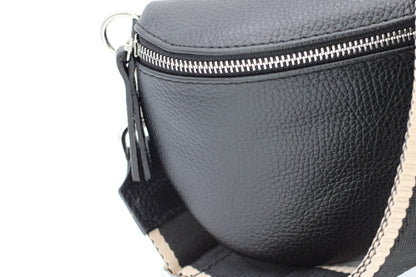Schwarze Leder-Gürteltasche mit silbernem Reißverschluss und verstellbarem Riemen. Modisches Accessoire, ideal für Reisen und Alltag.