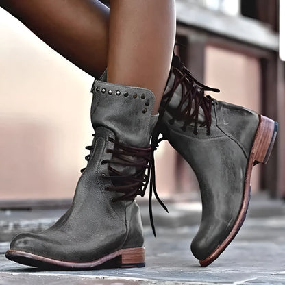 Damenstiefel aus Leder, grau, mit Nieten und Schnürung. Modische, robuste Boots für Herbst und Winter. Perfekt für urbanen Stil und Komfort.