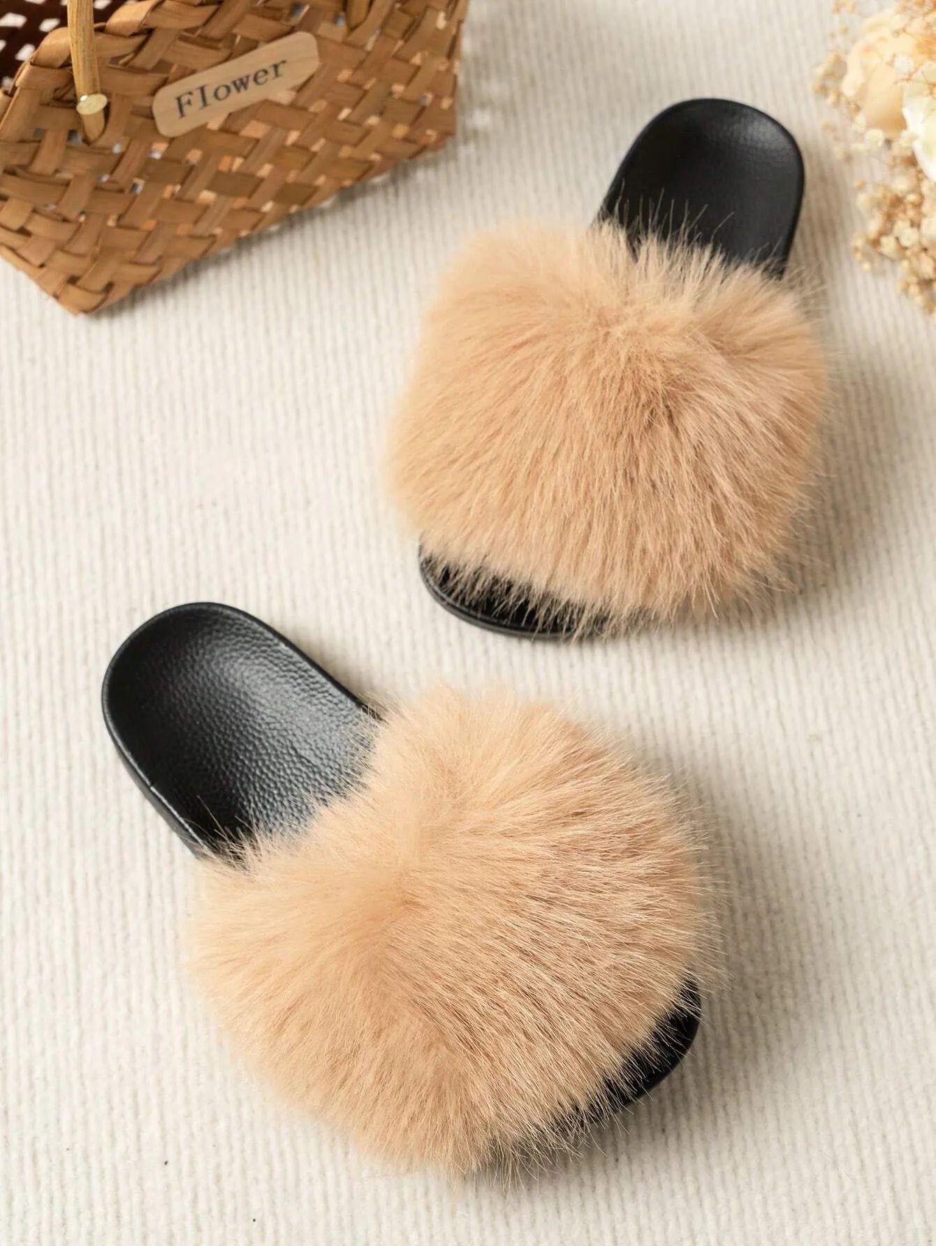 Damen-Pantoffeln mit flauschigem Kunstfell in Beige auf schwarzer Sohle, ideal für gemütliche Abende zu Hause. Trendige Hausschuhe, bequem und stilvoll.