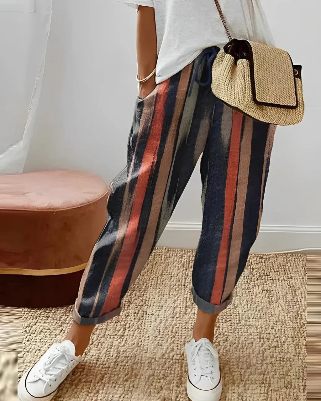 Damenhose mit bunten Streifen, kombiniert mit weißem T-Shirt und Sneakers. Perfekt für lässige Mode, bequem und stilvoll.