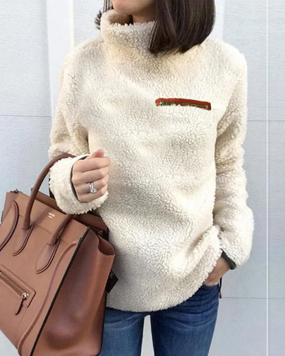 Damen Teddy-Fleece-Pullover in Creme, kuschelig und modisch, ideal für Herbst und Winter. Perfekt kombiniert mit brauner Lederhandtasche.