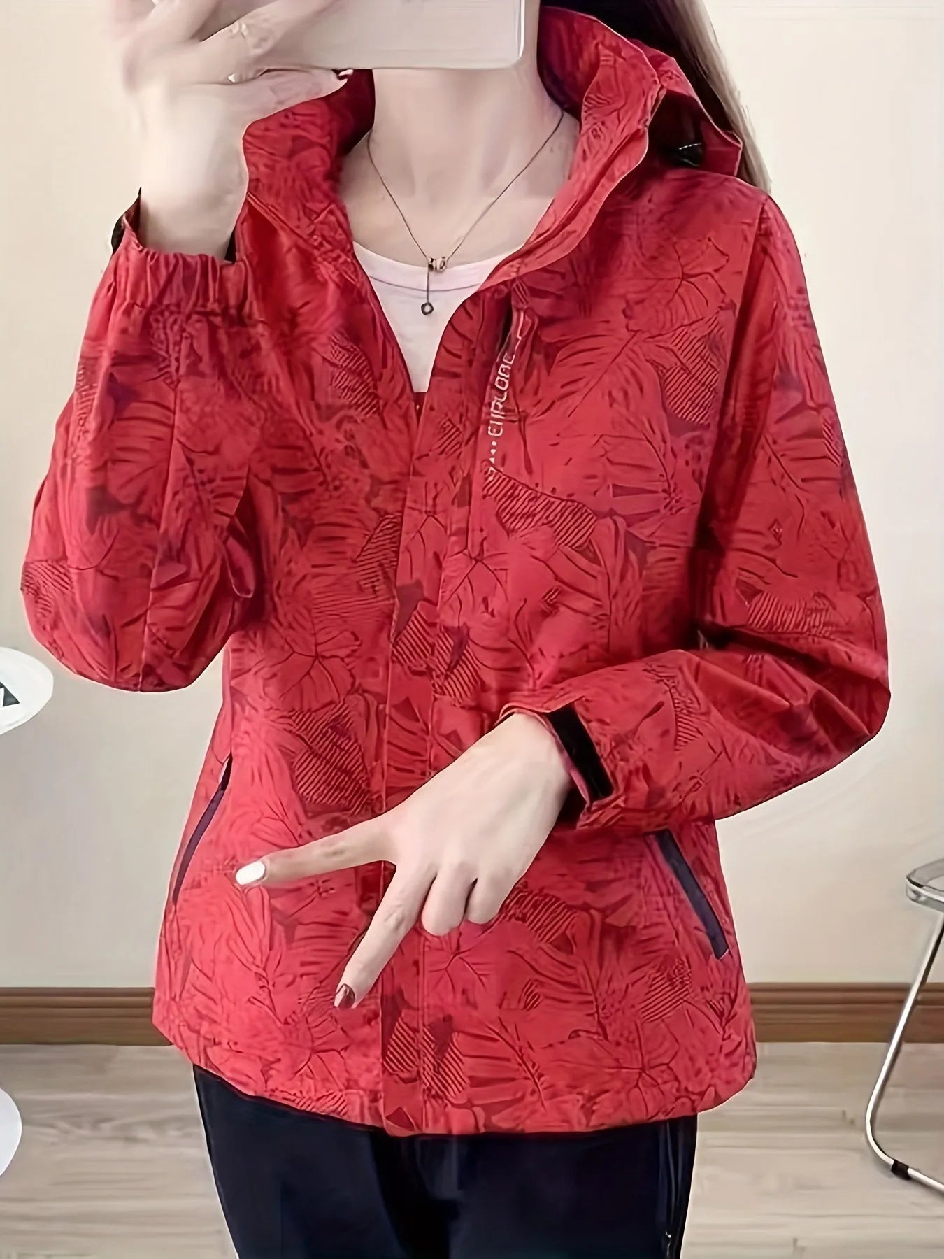 Rote Damenjacke mit floralem Muster, Reißverschluss und Kapuze. Perfekt für Outdoor-Aktivitäten. Modische, funktionale Damenbekleidung.