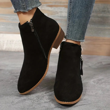 Schwarze Damen-Stiefeletten aus Wildleder mit Reißverschluss, flachem Absatz und modernem Design. Perfekt für Herbstmode und lässige Outfits.