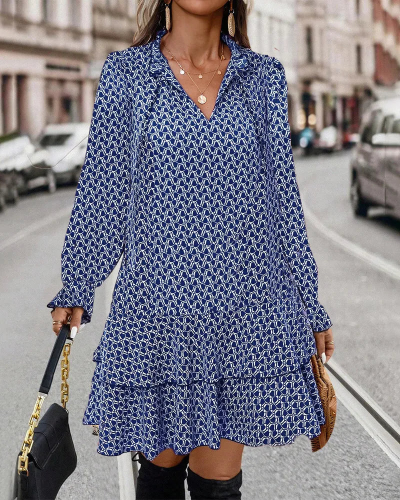 Damenmode: Elegantes blaues Kleid mit geometrischem Muster, V-Ausschnitt und langen Ärmeln. Perfekt für stilvolle Herbst- und Winteroutfits.