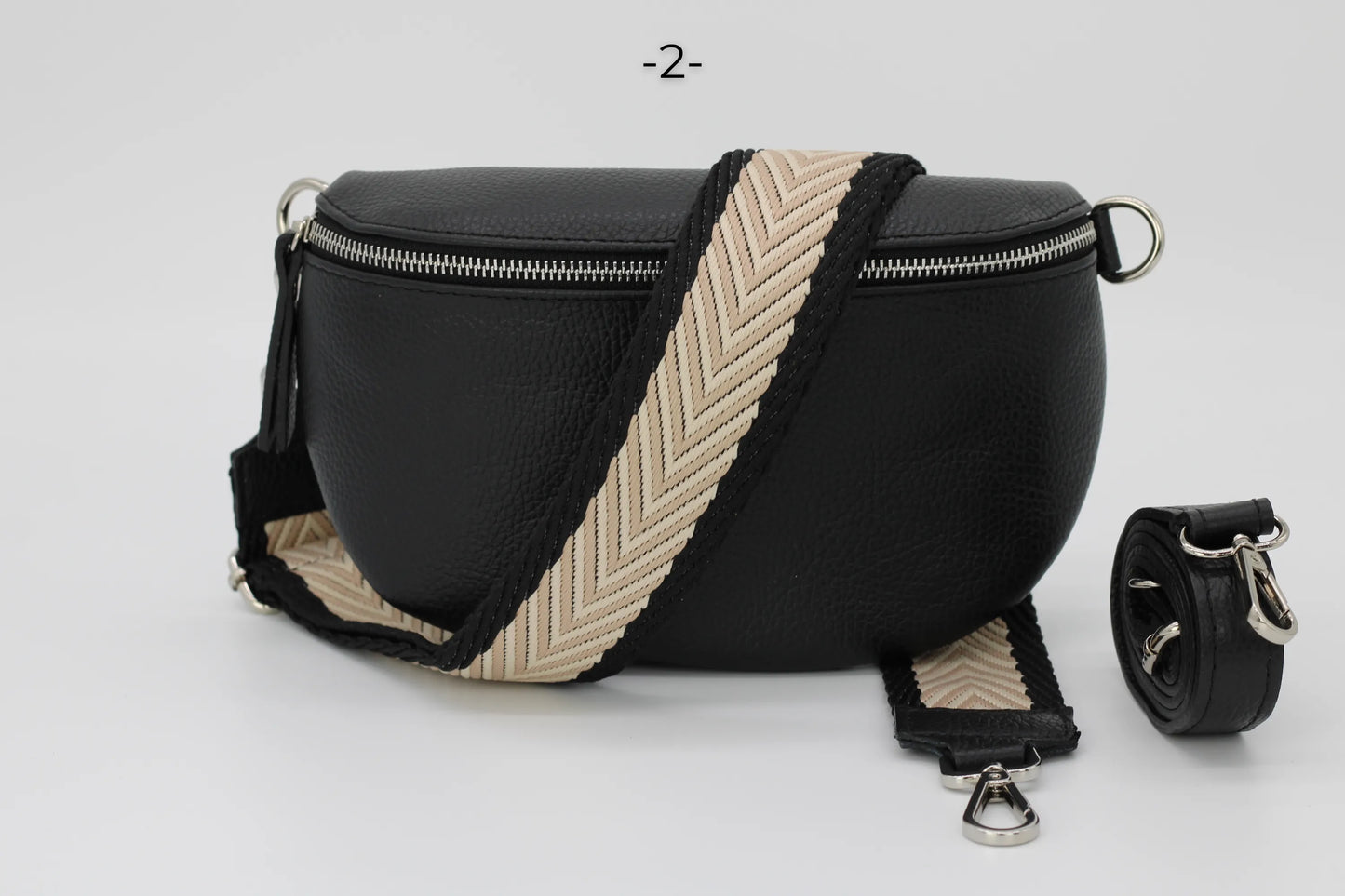 Schwarze Leder-Bauchtasche mit beige-schwarzem, verstellbarem Schultergurt. Stilvoll, praktisch, ideal für Alltag und Reisen.
