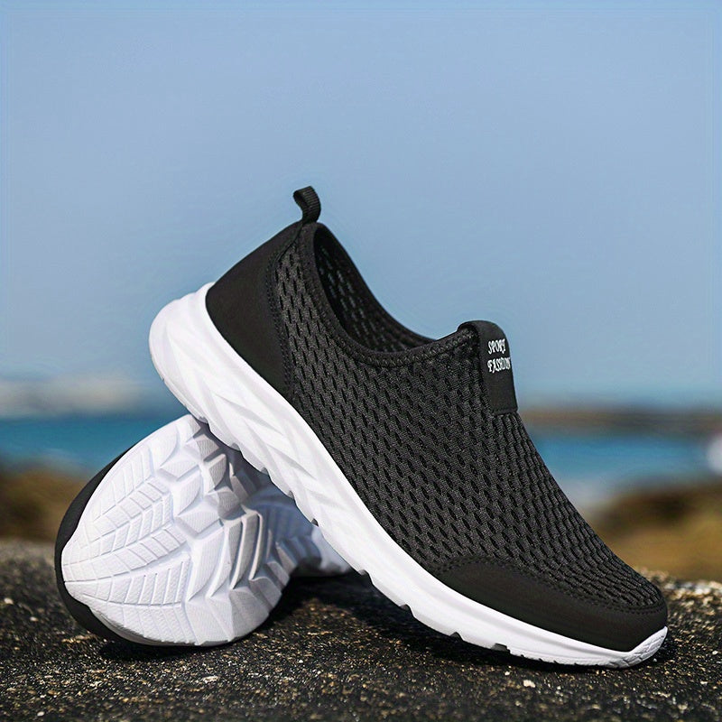Schwarze, atmungsaktive Sneaker mit weißer Sohle auf Felsen am Meer. Ideal für Sport und Freizeit. Leicht, komfortabel, modisch.