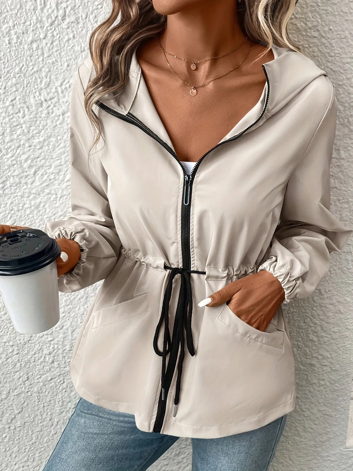 Damenjacke mit Kapuze, Reißverschluss und Kordelzug in Beige. Perfekt für den Herbst. Modischer Look, ideal für Freizeit und Outdoor-Aktivitäten.