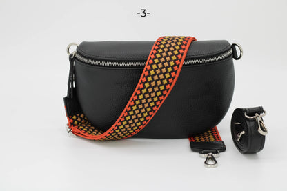 Schwarze Lederhandtasche mit auffälligem, gemustertem Schultergurt. Modisches Accessoire, ideal für Damen. Hochwertige Verarbeitung.