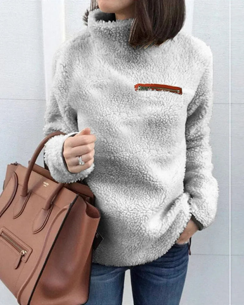 Damen Teddy-Fleece-Pullover in Grau, kuschelig und modisch, ideal für Herbst und Winter. Perfekt kombiniert mit brauner Lederhandtasche.