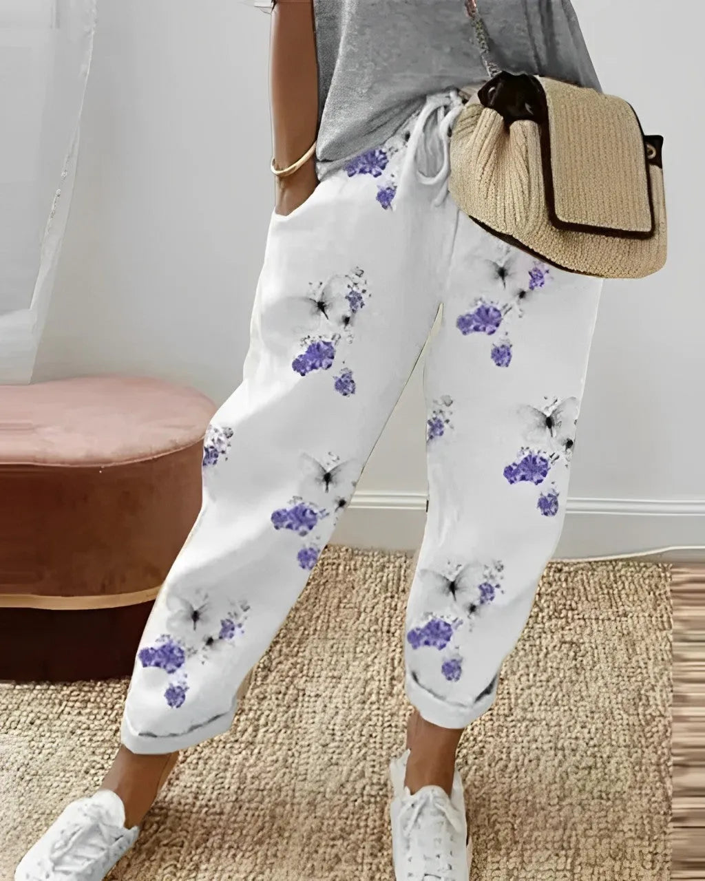 Damenhose mit Schmetterlings- und Blumenmuster, lässig, weiß, ideal für Freizeitmode. Perfekt kombiniert mit grauem T-Shirt und Sneakers.