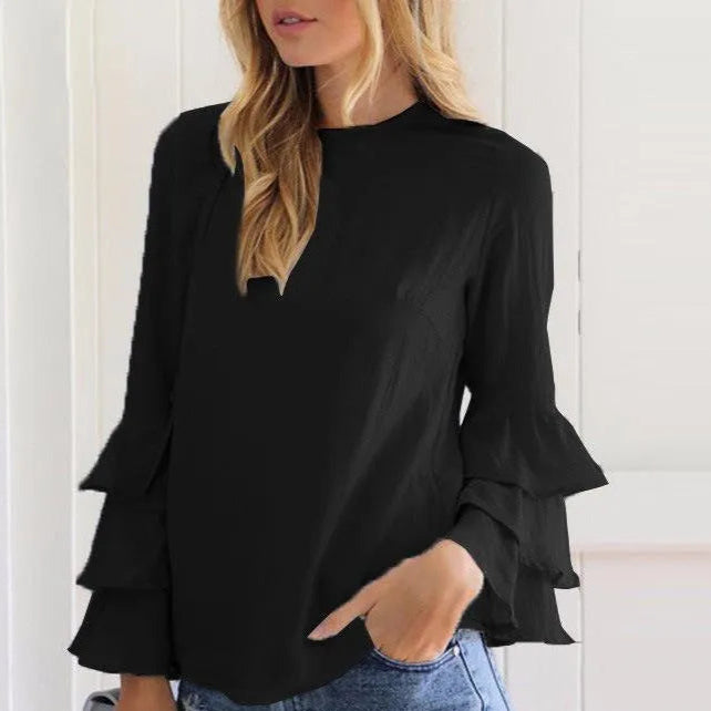 Schwarze Bluse mit Rüschenärmeln, kombiniert mit zerrissenen Jeansshorts. Modetrend, Damenbekleidung, lässiger Look, stilvoll und modern.