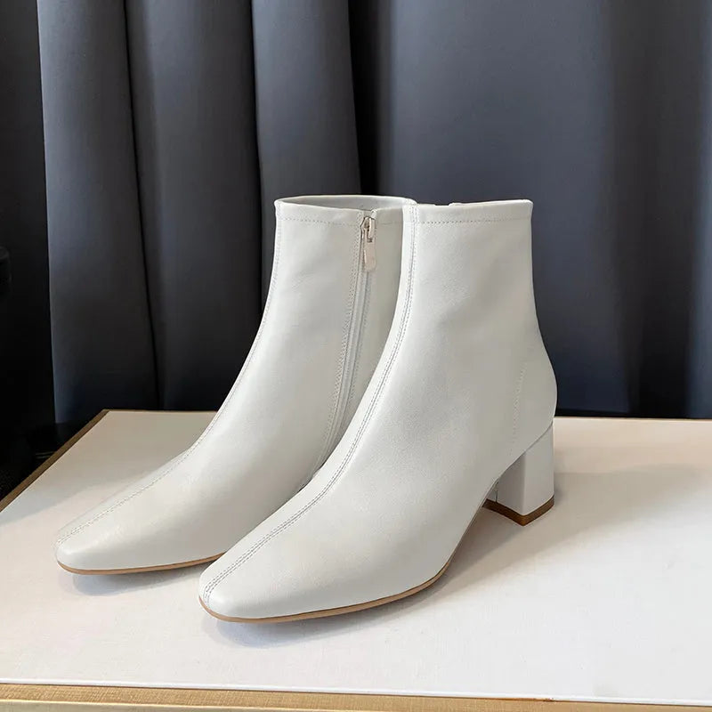 Weiße Damenstiefeletten mit Blockabsatz, elegantem Design und Reißverschluss. Perfekt für Herbstmode, bequem und stilvoll.