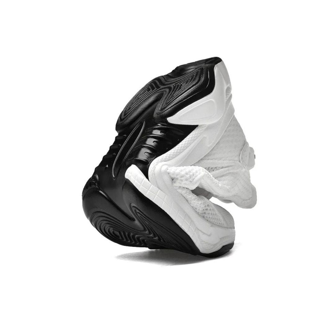 Schwarz-weißer Sportschuh, rutschfeste Sohle, atmungsaktives Material, modisches Design.