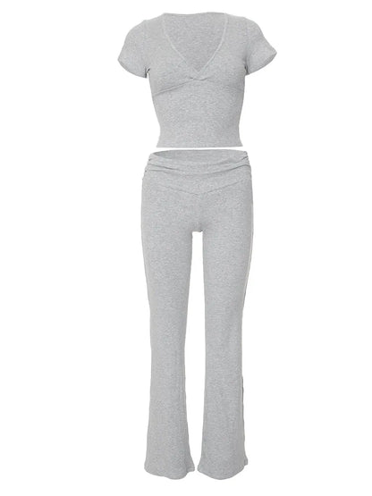 Graues Damen-Set aus weichem Jersey, bestehend aus kurzärmligem Oberteil und ausgestellter Hose. Perfekt für Freizeit und Komfort.