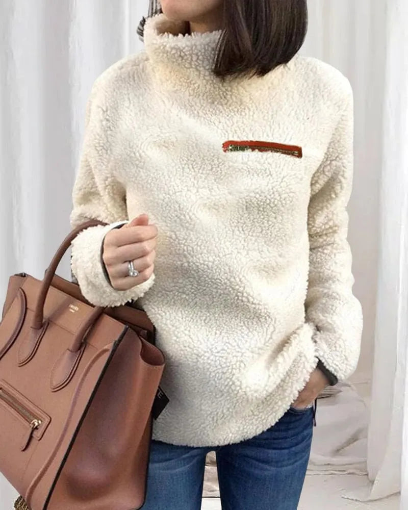 Damen Teddy-Fleece-Pullover in Creme, kuschelig und warm, ideal für Herbst und Winter. Perfekt kombiniert mit brauner Lederhandtasche.