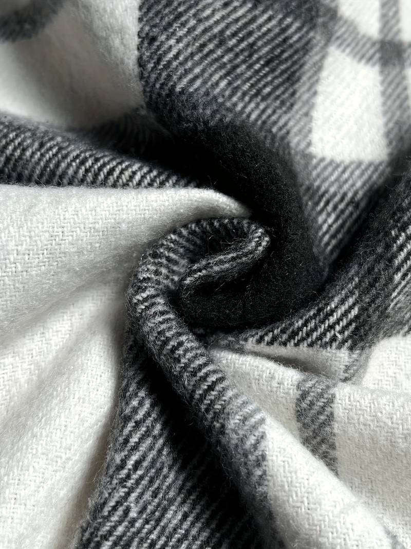 Weiche, karierte Wollstoffdecke in Schwarz-Weiß, ideal für gemütliche Winterabende. Hochwertige Textilien, stilvolles Design, warm und kuschelig.