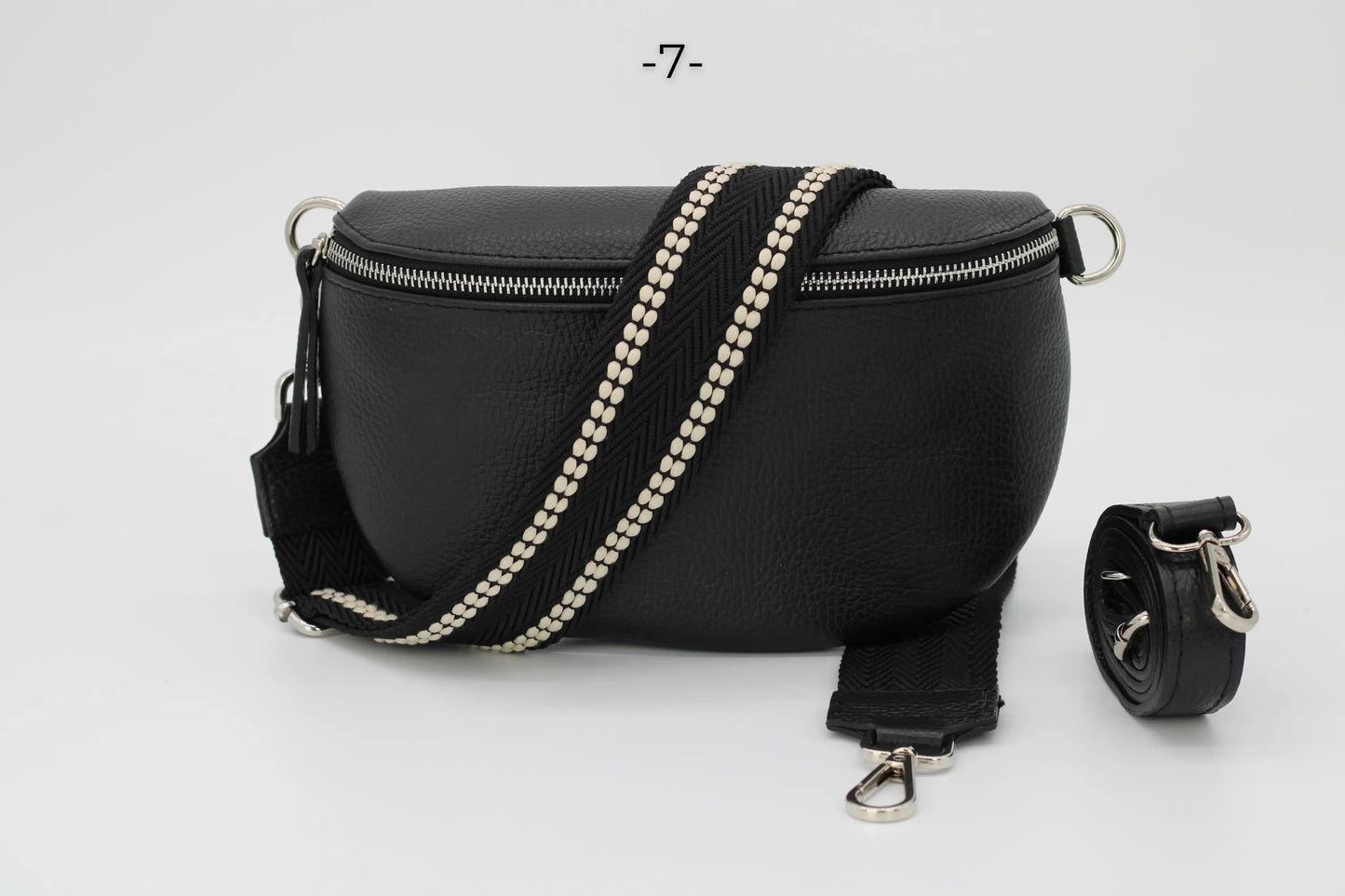 Schwarze Leder-Bauchtasche mit verstellbarem, gestreiftem Schultergurt und silbernem Reißverschluss. Modisches Accessoire für Damen und Herren.