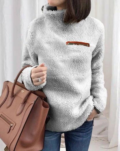 Damen Teddy-Fleece-Pullover in Grau, kuschelig und modisch, ideal für Herbst und Winter. Perfekt kombiniert mit brauner Lederhandtasche.