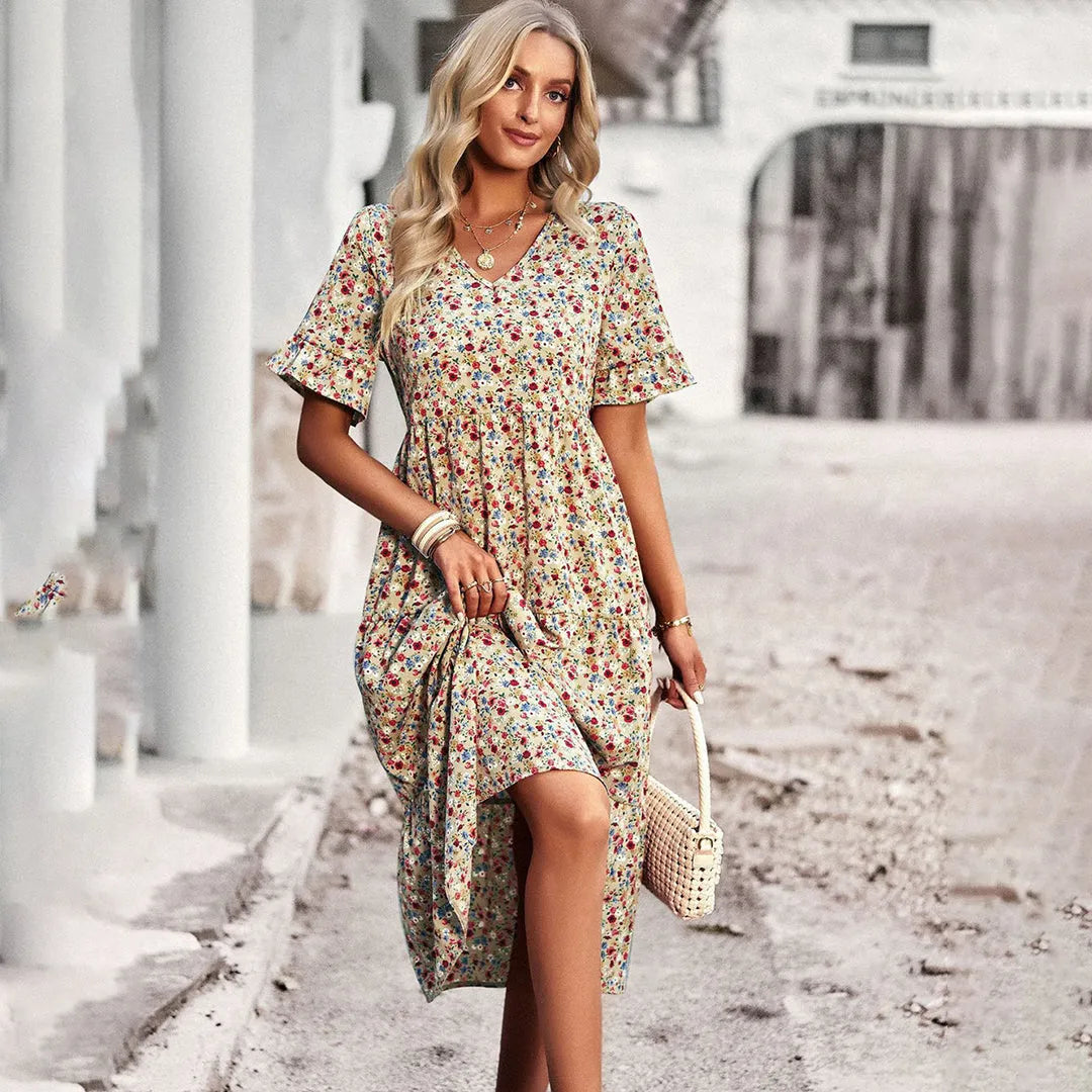 Frau in geblümtem Sommerkleid, posiert stilvoll auf Straße. Modetrend, Damenmode, Sommeroutfit, florales Design, eleganter Look.