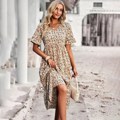 Frau in geblümtem Sommerkleid, posiert stilvoll auf Straße. Modetrend, Damenmode, Sommeroutfit, florales Design, eleganter Look.