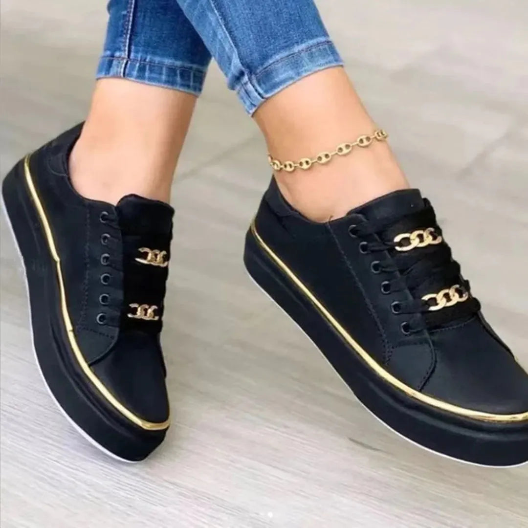 Schwarze Sneaker mit goldenen Ketten-Details, modisch und bequem, ideal für Damen. Perfekt für Freizeitoutfits und trendige Streetwear-Looks.
