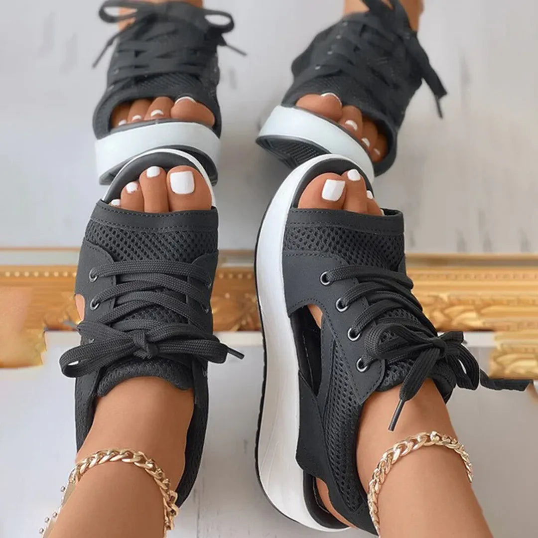 Schwarze Sneaker-Sandalen mit Netzstoff, offener Zehenpartie und weißer Sohle. Modisch, bequem, ideal für Sommer und Freizeit.