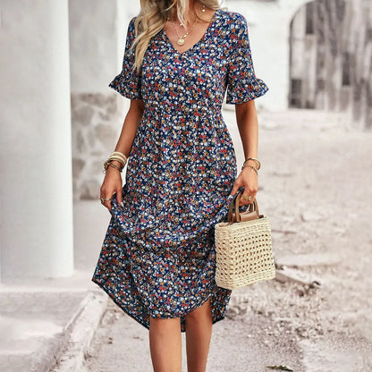 Frau in geblümtem Sommerkleid mit V-Ausschnitt und Rüschenärmeln, hält eine geflochtene Strohtasche. Perfekt für lässige Sommermode.