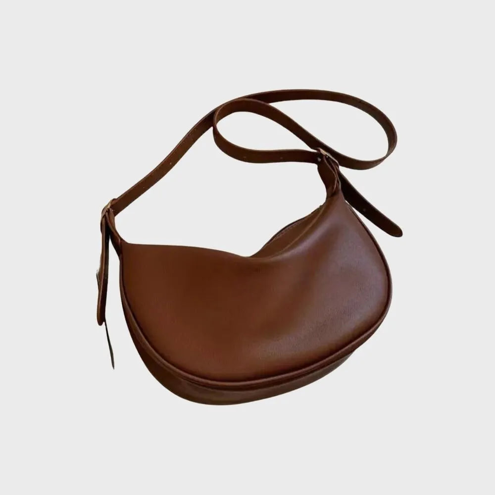 Braune Lederhandtasche im Halbmond-Design, stilvoll und modern. Perfekt für Damenmode, Accessoires und trendige Outfits.