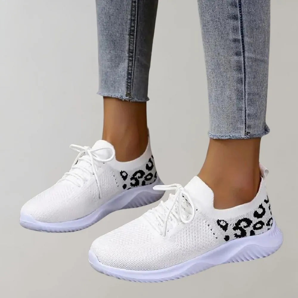 Weiße Sneaker mit Leopardenmuster, atmungsaktivem Mesh-Obermaterial und rutschfester Sohle. Perfekt für Damenmode und sportlichen Stil.