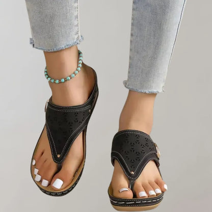 Schwarze Damen-Sandalen mit floralem Muster, bequemem Fußbett und Keilabsatz. Perfekt für Sommermode und lässige Outfits.