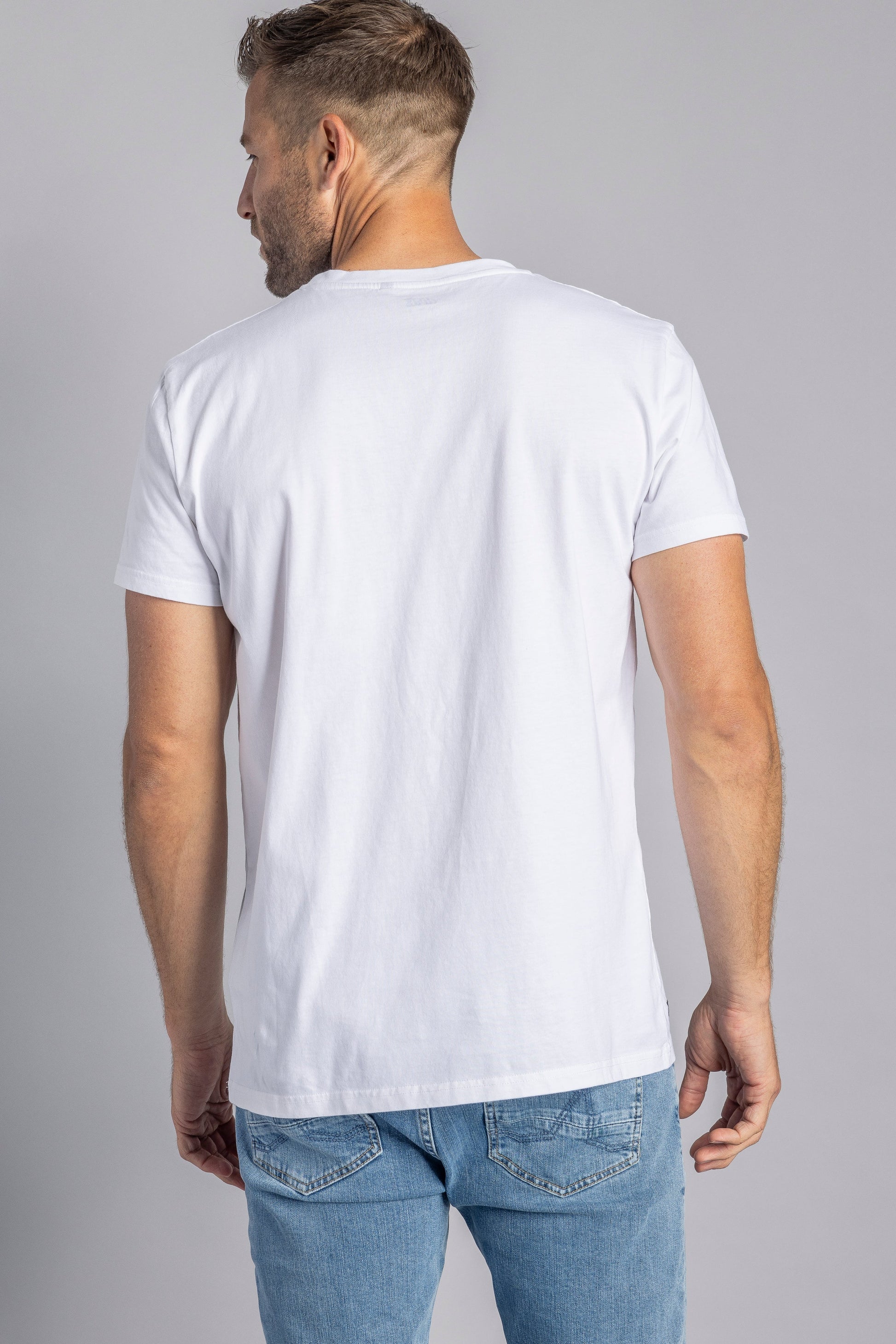 Mann in weißem T-Shirt und blauer Jeans von hinten, lässige Mode, Herrenbekleidung.