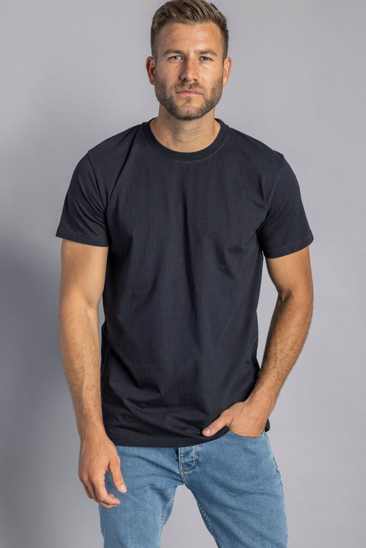 Mann in schwarzem T-Shirt und blauer Jeans, lässige Herrenmode, Freizeitkleidung, Studioaufnahme.
