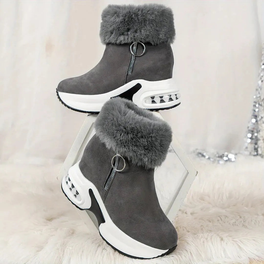 Graue Damenstiefeletten mit Fellbesatz, Reißverschluss und Keilabsatz. Modische Winterstiefel, bequem und stilvoll für kalte Tage.