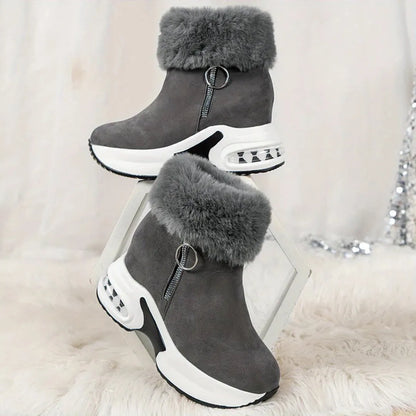Graue Damenstiefeletten mit Fellbesatz, Reißverschluss und Keilabsatz. Modische Winterstiefel, bequem und stilvoll für kalte Tage.