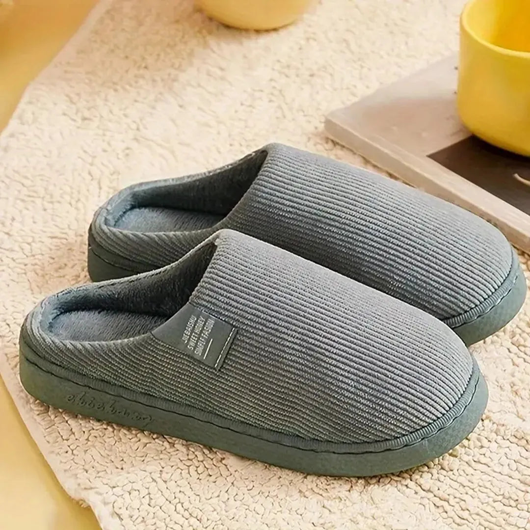 Graue Hausschuhe aus weichem Stoff, rutschfeste Sohle, ideal für Komfort und Wärme zu Hause. Perfekte Pantoffeln für gemütliche Winterabende.