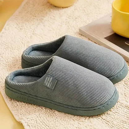 Graue Hausschuhe aus weichem Stoff, rutschfeste Sohle, ideal für Komfort und Wärme zu Hause. Perfekte Pantoffeln für gemütliche Winterabende.