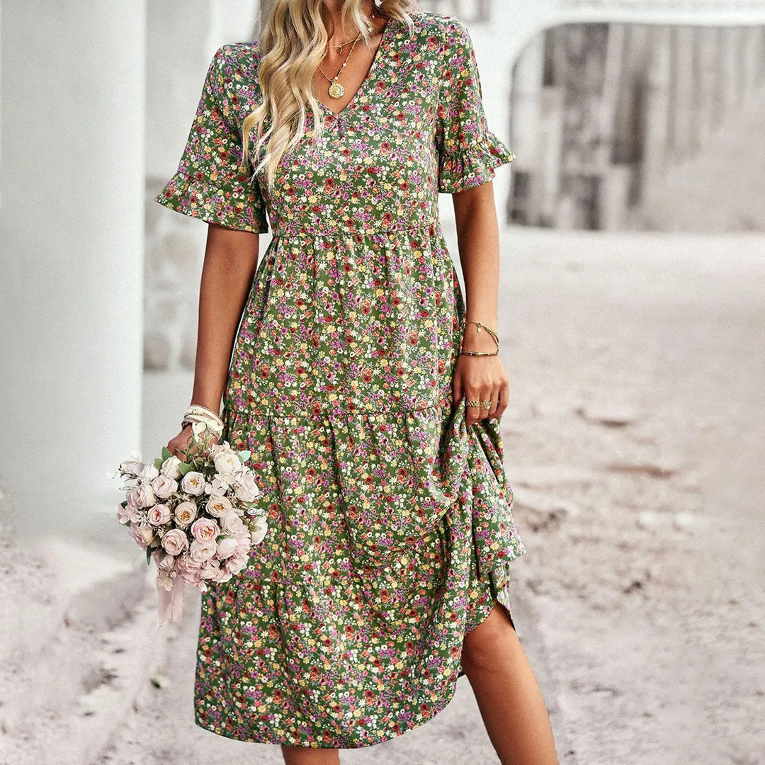 Frau in geblümtem Sommerkleid mit Blumenstrauß, romantischer Look, modisches Outfit, ideal für Frühling und Sommer, florales Design, Boho-Stil.