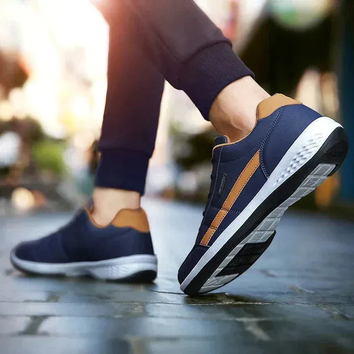 Dunkelblaue Sneaker mit braunen Akzenten, ideal für Herrenmode. Bequeme Freizeitschuhe mit rutschfester Sohle, perfekt für den Alltag.