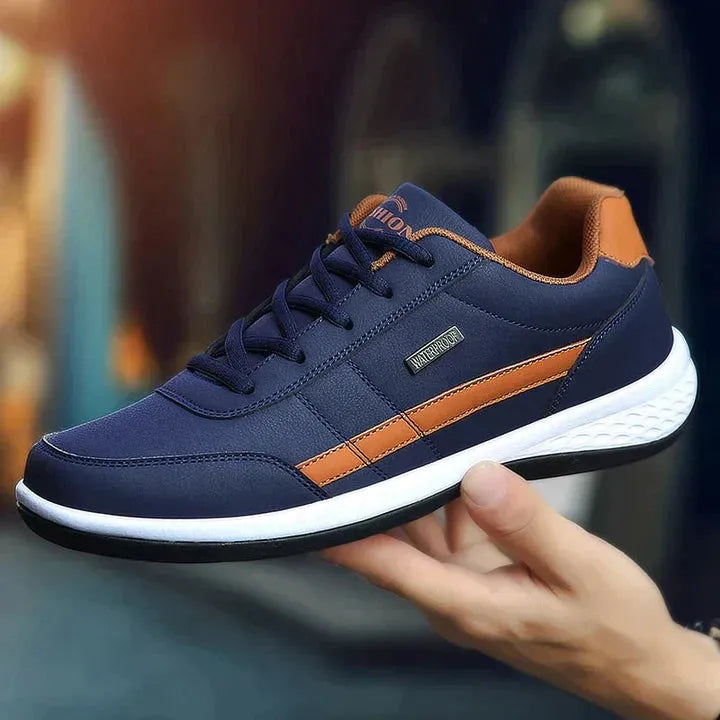 Dunkelblauer Sneaker mit braunen Akzenten, sportliches Design, bequeme Sohle, ideal für Herrenmode, Freizeit und Outdoor-Aktivitäten.