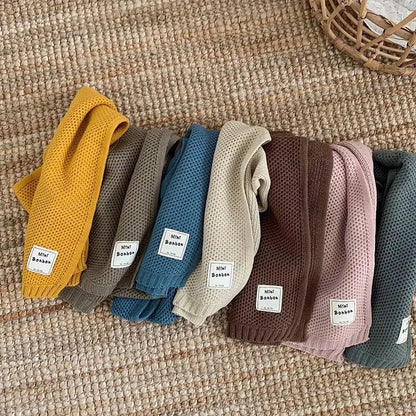 Bunte Babystrumpfhosen aus Baumwolle auf Teppich, ideal für Herbstmode. Weiche, atmungsaktive Materialien, perfekt für Komfort und Stil.