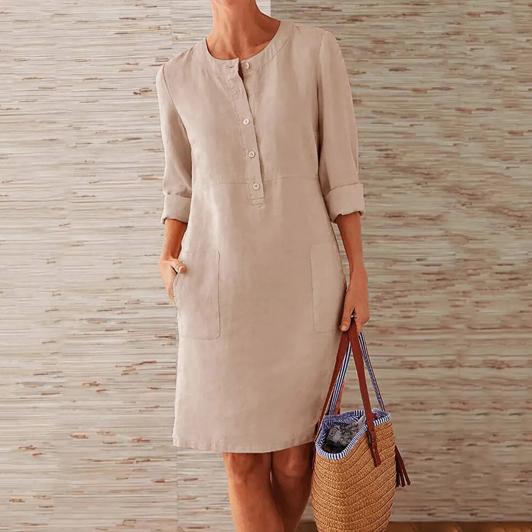 Damen Leinenkleid in Khaki mit Knopfleiste und Taschen, ideal für Sommermode. Perfekt kombiniert mit einem geflochtenen Korb für einen lässigen Look.