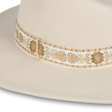 Beiger Fedora-Hut mit breiter Krempe, goldener Verzierung, Damenmode, stilvoller Kopfbedeckung.