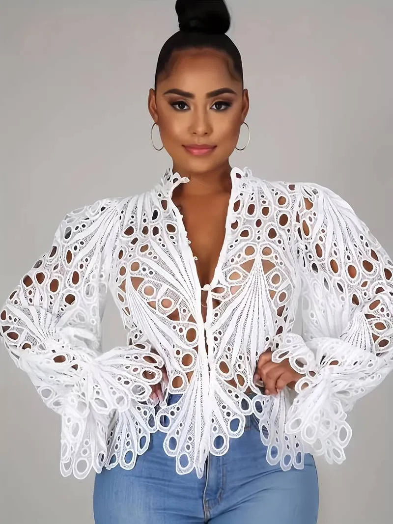 Elegante weiße Spitzenbluse mit auffälligem Lochmuster, ideal für modische Outfits. Perfekt kombinierbar mit Jeans für einen stilvollen Look.